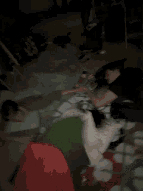 a group of people laying on a bed with blankets and pillows