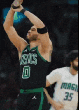 a basketball player wearing a celtics jersey reaches up to catch a ball