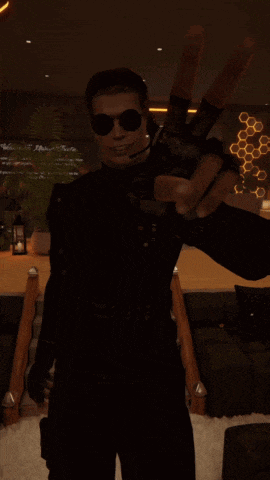 a man wearing sunglasses and gloves is standing in a dark room