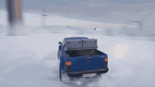 a blue truck is driving through the snow with a sign that says snooper