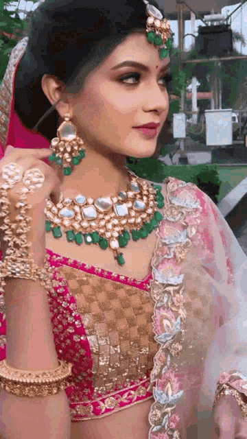 a woman wearing a necklace and earrings is looking at the camera