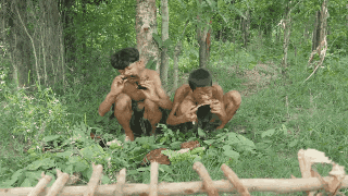 two boys sit in the grass playing instruments