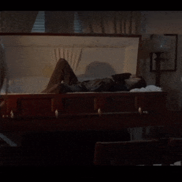 a man is laying in a coffin in a room
