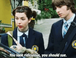 a boy and a girl in school uniforms are standing next to each other and the girl is saying you look ridiculous you should sue