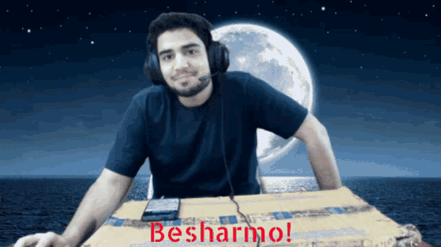 a man wearing headphones sits at a table with the words besharmol written on the bottom