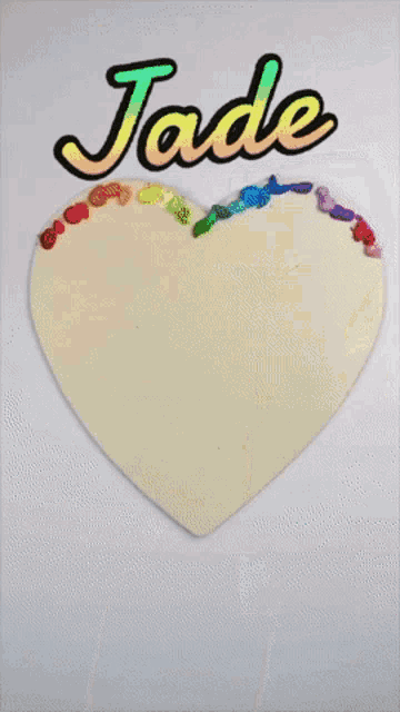 a brush is being used to paint a heart with the name jade above it