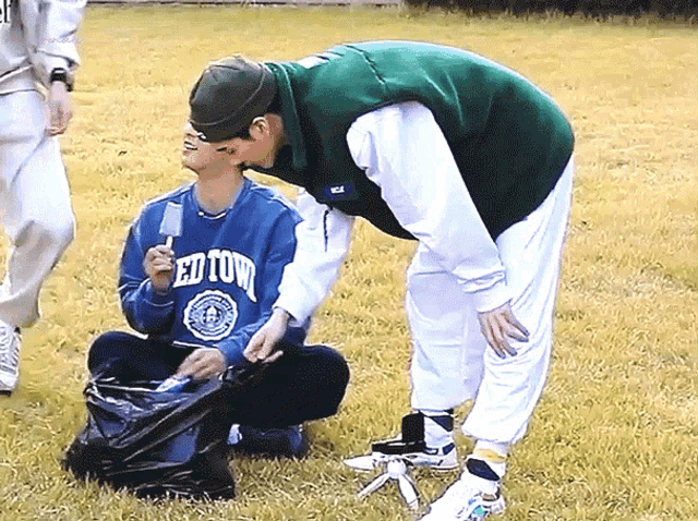 a person wearing a sweatshirt that says ed town is sitting on the grass