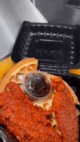 a waffle with chicken and syrup in a container