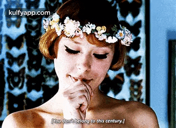 a woman with a flower crown on her head is talking to someone .