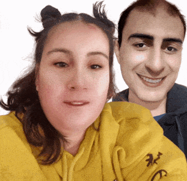 a woman wearing a yellow hoodie is next to a man