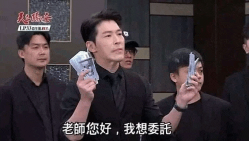 a man in a suit and tie is holding a bunch of money in his hands .