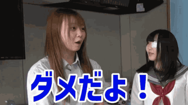 a girl with a bandage on her eye is standing next to another girl with chinese writing on the screen