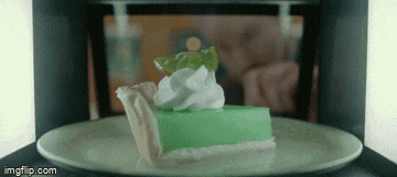 a slice of key lime pie with whipped cream on top is being cooked in a microwave oven .