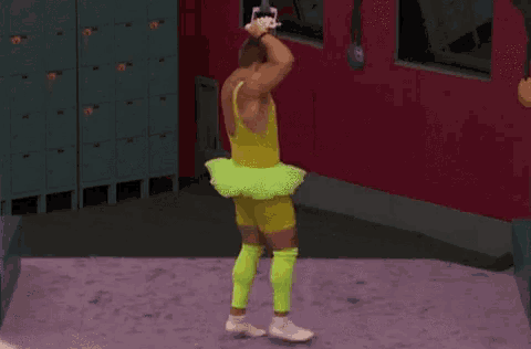 a man in a yellow tank top and a green tutu