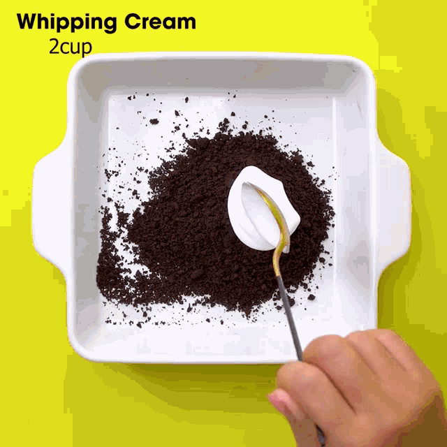 a person is whipping cream in a bowl of crumbs with a spoon