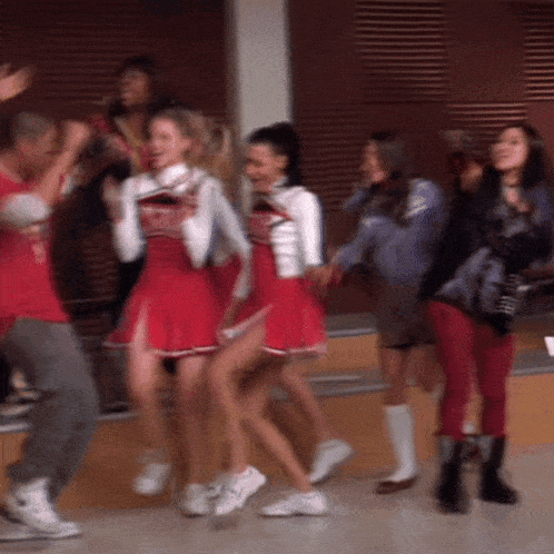 a group of cheerleaders are dancing together in a gym