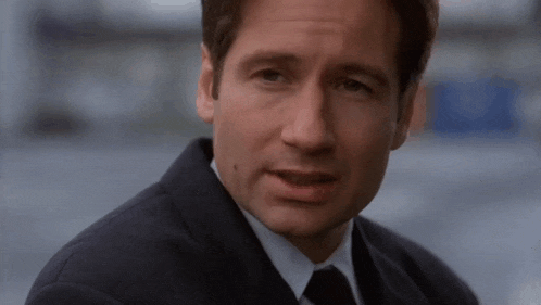 a man in a suit and tie is making a funny face