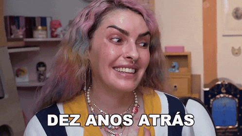 a woman with pink hair is smiling with the words dez anos atrás written on her face