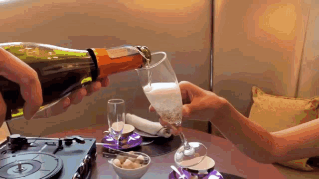 a bottle of champagne is being poured into a wine glass