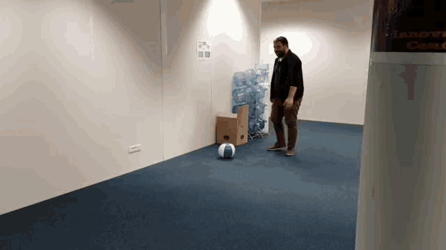 a man playing with a ball in an empty room with a sign on the wall that says ' la salle '