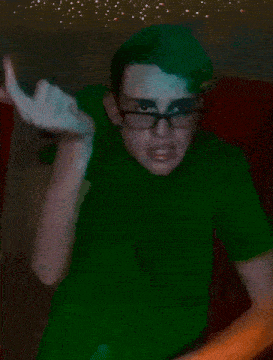 a man wearing glasses and a green shirt is making a face