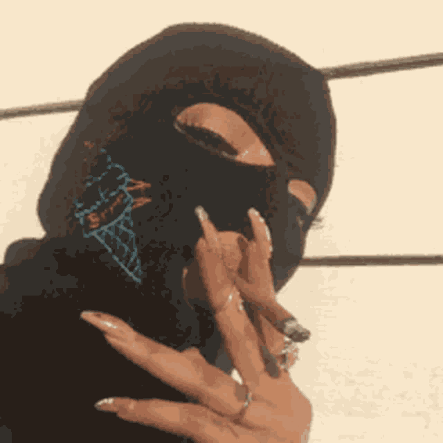 a woman wearing a ski mask is smoking a cigarette