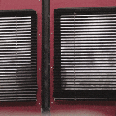 black blinds on a red wall with a black frame