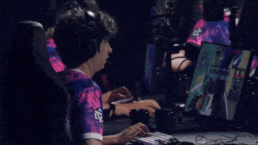 a man wearing headphones and a shirt that says king sits in front of a computer