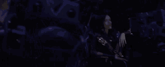 a woman with red hair is standing in a dark room with a gun .