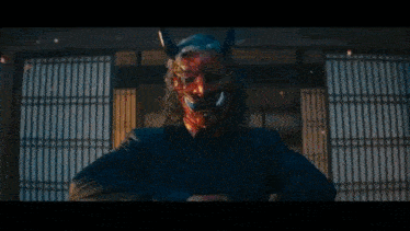 a demon with horns is holding a sword in a dark room