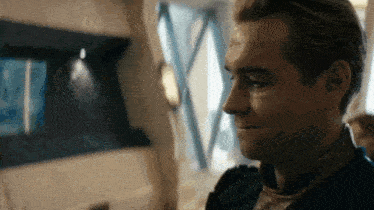 a close up of a man 's face looking at a screen in a room .