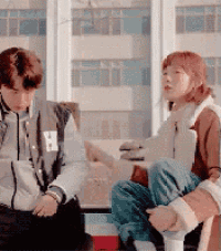 a man and a woman are sitting next to each other .