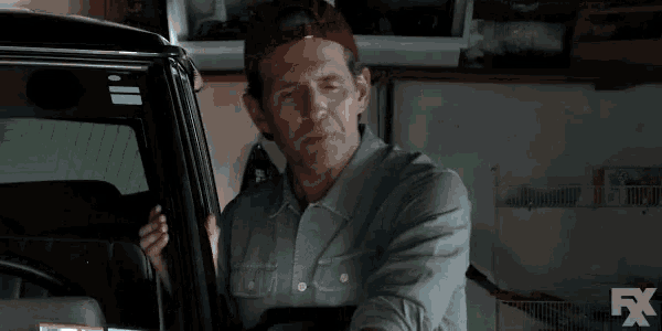 a man in a baseball cap is standing next to a car and says be gone from me