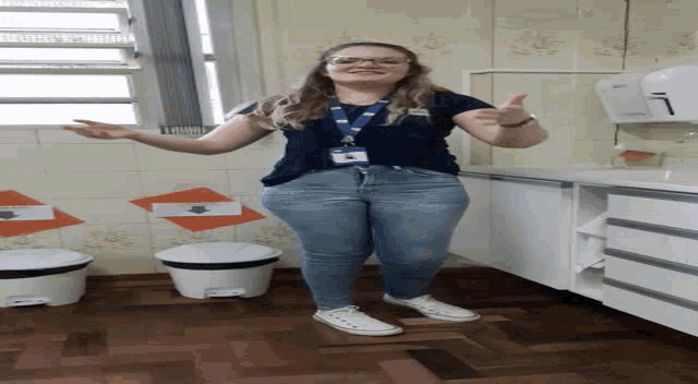 a woman with a lanyard around her neck is standing in front of a white trash can