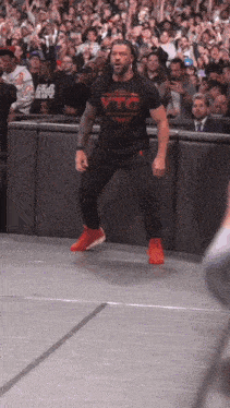 a wrestler wearing a black shirt that says vtc on it