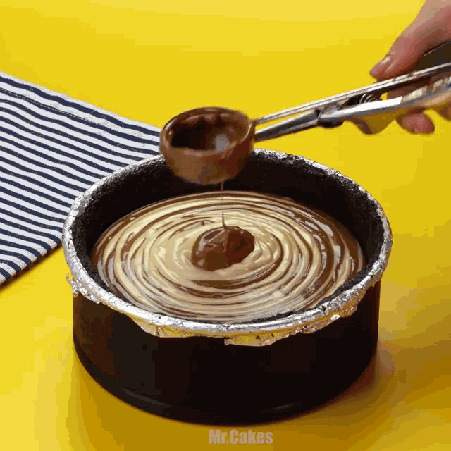 a person is scooping chocolate into a cake with the words mr.cakes below