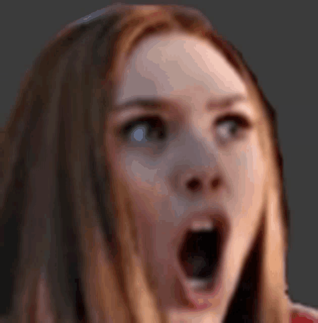 a close up of a woman 's face with a surprised look on her face .