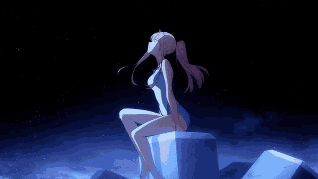 a girl in a swimsuit is sitting on a block in the dark