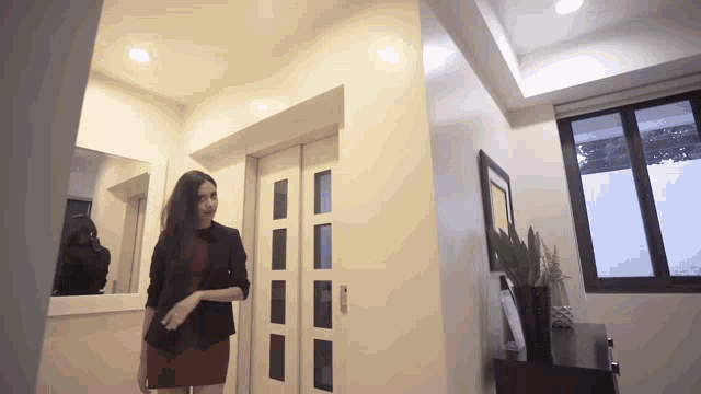 a woman in a red dress is standing in front of a door