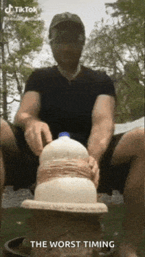a man is sitting on a stool with a bottle of milk in his hands .
