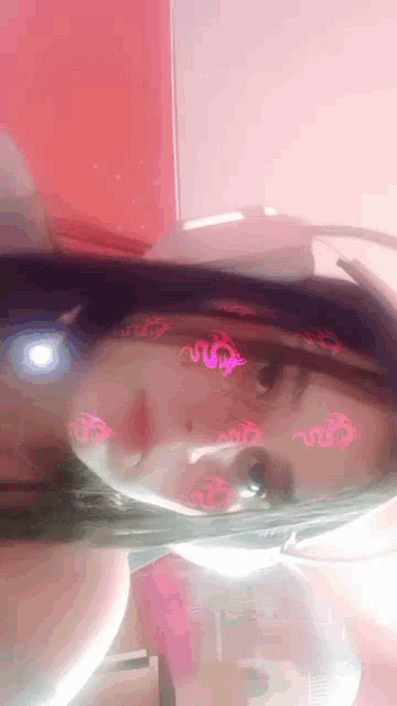 a close up of a woman 's face with pink dragons on it .
