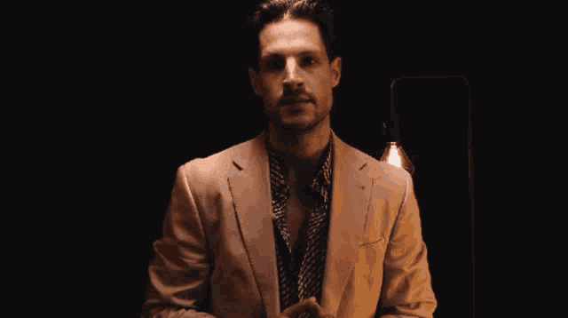 a man in a suit says cap bailey is here in a dark room