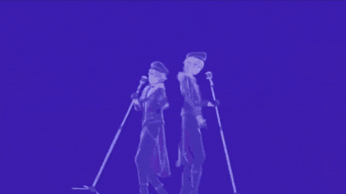 a couple of people singing into microphones in a dark room