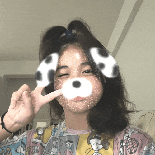 a girl with dalmatian ears on her face is making a peace sign