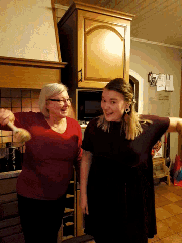 a woman in a red shirt is standing next to a woman in a black shirt