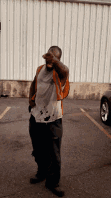 a man in an orange vest is pointing at something