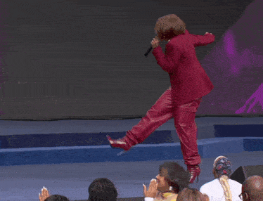 a woman in a red suit is standing on one leg in front of a screen that says tph dallas