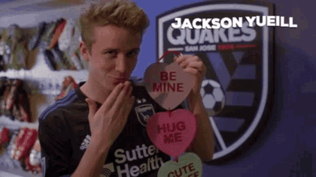 a man holding a valentine 's day card that says be mine