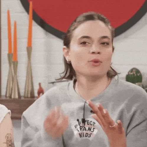 a woman wearing a grey sweater that says protect trans kids
