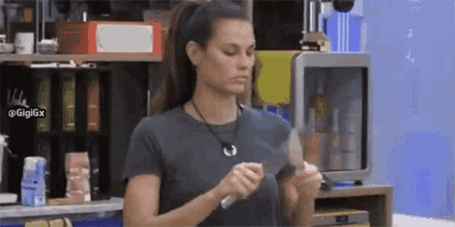 a woman is holding a knife and a spoon in her hands in a kitchen .